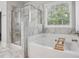 Elegant bathroom with a separate shower and soaking tub, complemented by marble finishes for a spa-like experience at 821 Ethereow Ct, Lawrenceville, GA 30046