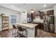Modern kitchen features an island with bar seating, dark cabinets, and stainless steel appliances at 821 Ethereow Ct, Lawrenceville, GA 30046
