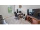 Functional office area with a sleek desk, comfortable chair, and large TV for entertainment at 821 Ethereow Ct, Lawrenceville, GA 30046