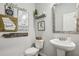 Stylish powder room features a pedestal sink, a toilet, and decorative wall art at 821 Ethereow Ct, Lawrenceville, GA 30046