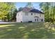Expansive backyard view featuring a lush lawn, mature trees, and a traditional home at 120 Julia Ct, Fayetteville, GA 30214