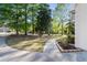 View of curved driveway with manicured landscaping and lush mature trees at 120 Julia Ct, Fayetteville, GA 30214