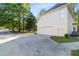 View of a two-car garage with extended driveway and lush landscaping at 120 Julia Ct, Fayetteville, GA 30214