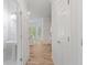 Hallway with view of powder room and kitchen area; natural light and hardwood flooring at 120 Julia Ct, Fayetteville, GA 30214
