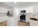 Well-lit kitchen with white cabinets, stainless steel appliances, and hardwood floors at 120 Julia Ct, Fayetteville, GA 30214