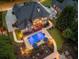 Elevated backyard view featuring an in-ground pool, manicured gardens, and an outdoor kitchen at 2439 Huntington Park Nw Dr, Acworth, GA 30101