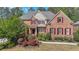 Charming brick home featuring a meticulously landscaped front yard and mature trees at 2439 Huntington Park Nw Dr, Acworth, GA 30101