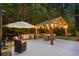 Outdoor kitchen and dining area featuring built-in appliances, seating, and overhead lighting at 2439 Huntington Park Nw Dr, Acworth, GA 30101