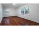 Bedroom with laminate flooring, two windows, and white walls at 5101 Rockbridge Rd, Stone Mountain, GA 30088