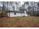 View of the back of the house showing the brick chimney and a wooden deck at 5101 Rockbridge Rd, Stone Mountain, GA 30088