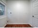 Bright laundry room with wood-look floors, white walls, and a window offering natural light at 5101 Rockbridge Rd, Stone Mountain, GA 30088