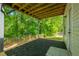 Inviting back patio featuring a mulch bed, rustic wood beams, and a view of the lush greenery in the yard at 5135 Gable Ridge Way, Sugar Hill, GA 30518