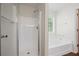 Bright bathroom featuring a combined shower and tub with white fixtures and a large window at 5135 Gable Ridge Way, Sugar Hill, GA 30518