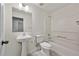 Functional bathroom with a tub-shower combination, pedestal sink, and tiled flooring at 5135 Gable Ridge Way, Sugar Hill, GA 30518