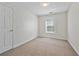 Clean bedroom with neutral carpet, white walls, and a window allowing natural light at 5135 Gable Ridge Way, Sugar Hill, GA 30518