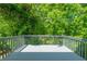 Spacious gray deck with wooden railing, overlooking a lush green landscape at 5135 Gable Ridge Way, Sugar Hill, GA 30518