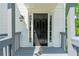 Inviting entryway featuring a black front door, sidelights, and classic sconce at 5135 Gable Ridge Way, Sugar Hill, GA 30518