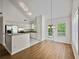 Bright kitchen featuring white cabinets, stainless steel appliances, and hardwood floors at 5135 Gable Ridge Way, Sugar Hill, GA 30518