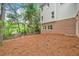 Back of home features a yard with tall trees and pine straw at 515 Old Chartwell Xing, Alpharetta, GA 30022