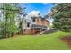 Beautiful backyard view of the two-story home with large deck and well-manicured lawn, perfect for outdoor entertaining at 515 Old Chartwell Xing, Alpharetta, GA 30022
