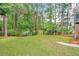 Lush green backyard with mature trees, grass and garden edging, creating a private and peaceful retreat at 515 Old Chartwell Xing, Alpharetta, GA 30022