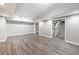 Bright, unfinished basement showcasing vinyl floors, neutral gray walls and an entrance to the upper floor at 515 Old Chartwell Xing, Alpharetta, GA 30022