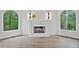 Close up of the marble fireplace with decorative sconces and flanking windows overlooking lush greenery at 515 Old Chartwell Xing, Alpharetta, GA 30022