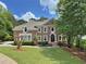 Elegant brick home showcasing a lush green lawn, manicured landscaping, and traditional design at 515 Old Chartwell Xing, Alpharetta, GA 30022