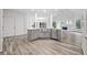 Kitchen boasts a large stainless steel sink, gray cabinetry, and view to an open floor plan at 515 Old Chartwell Xing, Alpharetta, GA 30022