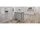 Spacious kitchen with white cabinets, island with gray accent, and view to fireplace at 515 Old Chartwell Xing, Alpharetta, GA 30022