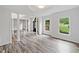 Bright living room featuring hardwood style flooring, columns, large windows, and a modern front door at 515 Old Chartwell Xing, Alpharetta, GA 30022
