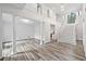 Open living space with columns, staircase to the second floor, and light gray wood flooring throughout at 515 Old Chartwell Xing, Alpharetta, GA 30022