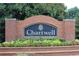 Welcoming brick sign at the entrance of Chartwell community surrounded by vibrant flowers and manicured landscaping at 515 Old Chartwell Xing, Alpharetta, GA 30022