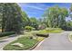 Street view of well-maintained landscaping and a glimpse of a charming home within the lush, green community at 515 Old Chartwell Xing, Alpharetta, GA 30022