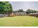 Large, grassy backyard with mature trees and a wooden fence, perfect for outdoor activities at 1399 Pollard Sw Dr, Atlanta, GA 30311