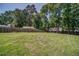 Large grassy back yard surrounded by a wooden fence and mature shade trees at 1399 Pollard Sw Dr, Atlanta, GA 30311