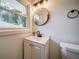 Bathroom featuring a black faucet, round mirror and modern lighting at 1399 Pollard Sw Dr, Atlanta, GA 30311
