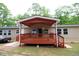 Back porch with painted wooden deck and awning on a home with light tan vinyl siding at 208 Holiday Way, Carrollton, GA 30116