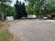 Gravel drive features parking for multiple vehicles, including trailer and covered parking at 208 Holiday Way, Carrollton, GA 30116