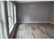 An open concept living room offers natural light and modern light wood floors at 208 Holiday Way, Carrollton, GA 30116