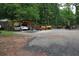 Large parking area with a covered spot for a car and various pieces of heavy equipment at 208 Holiday Way, Carrollton, GA 30116