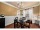 Traditional dining room features hardwood floors, chandelier, and ample natural light from the nearby window at 4215 Idlewood Dr, Cumming, GA 30040