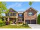 Beautiful brick home with a two-car garage, manicured lawn, an American flag and covered porch at 4215 Idlewood Dr, Cumming, GA 30040
