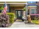 Inviting front porch with potted plants, an American flag, and decorative door with glass at 4215 Idlewood Dr, Cumming, GA 30040