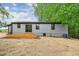 Back of home featuring a wooden deck, gray exterior siding, and black window trim at 4901 Prince Se Rd, Smyrna, GA 30082