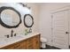 Bathroom vanity featuring double sinks, modern fixtures, decorative mirrors, and wood cabinets at 4901 Prince Se Rd, Smyrna, GA 30082