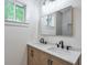 Bathroom vanity with double sinks, modern fixtures, wood cabinets, and modern mirror at 4901 Prince Se Rd, Smyrna, GA 30082