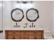 Bathroom vanity featuring double sinks, modern fixtures, decorative mirrors, and wood cabinets at 4901 Prince Se Rd, Smyrna, GA 30082