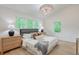 Serene bedroom showcasing large windows, a stylish light fixture, and natural wood nightstands at 4901 Prince Se Rd, Smyrna, GA 30082