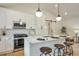 Bright kitchen with stainless steel appliances, white cabinets and an island with barstool seating at 4901 Prince Se Rd, Smyrna, GA 30082